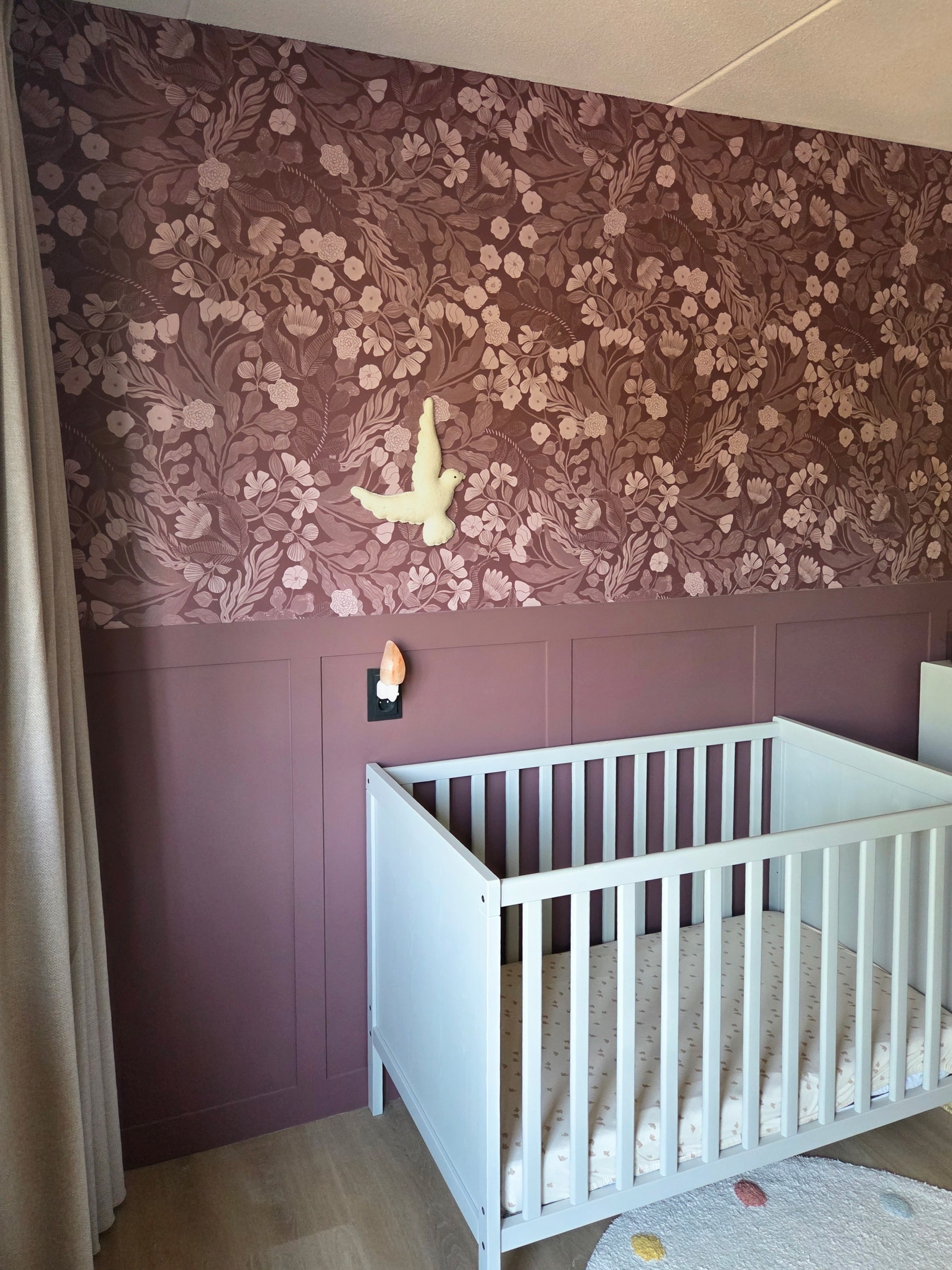 Vintage Botanica behang in mauve boven een mauve lambrisering in de babykamer